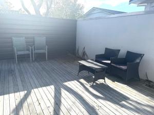 a patio with two chairs and a table and a bench at The Black Shed Studio in New Plymouth