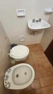 ein Badezimmer mit Toilette und Waschbecken in der Unterkunft Arenas Departamentos in Mina Clavero + 42 Fotos