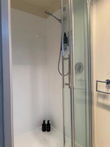 a shower in a bathroom with a glass shower stall at The Black Shed Studio in New Plymouth
