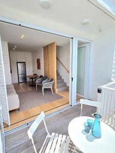 a living room with sliding glass doors and a table and chairs at Villa in the heart of Matakana in Matakana