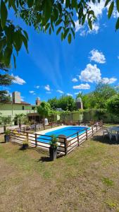 ein Schwimmbad mit einem Holzzaun in der Unterkunft Arenas Departamentos in Mina Clavero