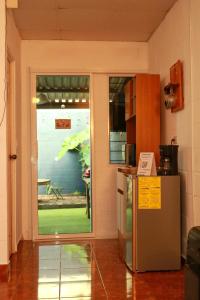een keuken met een koelkast en een deur naar een tuin bij Las Palmeritas in Ahuachapán