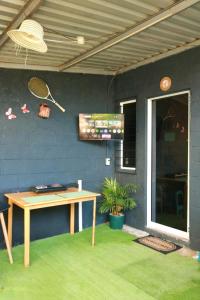 een terras met een tafel en een tennisracket aan de muur bij Las Palmeritas in Ahuachapán