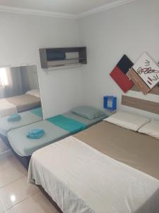 マリンガにあるKit Net 5 azul cama casalの部屋にベッドが3つある部屋