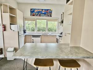 a kitchen with a counter and two chairs in it at Cheltenham Villa in Hanmer Springs