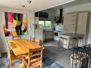 a kitchen and dining room with a wooden table and chairs at Cheltenham Villa in Hanmer Springs
