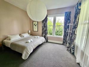 a bedroom with a bed and a large window at Cheltenham Villa in Hanmer Springs +16 photos