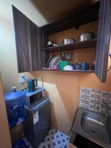 a small kitchen with a sink and a microwave at Bukoto pal in Kampala +2 photos
