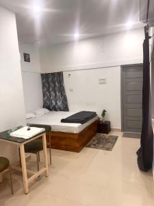 a small bedroom with a bed and a table at Vibes stay in 5 in Hyderabad