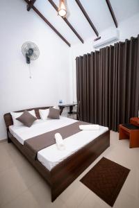 NikawatawanaにあるAirways Hotelのベッドルーム1室(茶色のカーテンが付いた大型ベッド1台付)