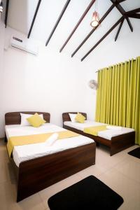 NikawatawanaにあるAirways Hotelの緑のカーテンがかかった部屋にベッドが2つ