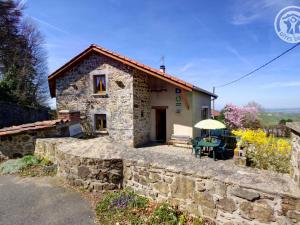 a small stone house with a stone wall at Gîte au cœur des Monts du Lyonnais, jusqu'à 5 pers., animaux acceptés - FR-1-496-102 in Fontanès