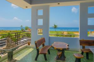 a room with a table and chairs and a view of the ocean at Lộc An Lý Sơn Motel in Ly Son