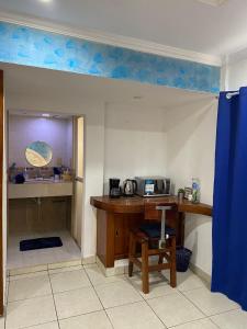 Una habitación con un escritorio y una cocina con techo azul. en Home Rent Minatitlán, en Minatitlán