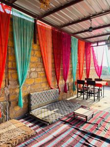 a room with a couch and some colorful curtains at Hotel Muskan Heritage in Jaisalmer