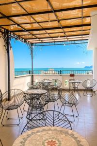 a patio with tables and chairs and a view of the ocean at Thanh Vy Hotel in Phu Quoc