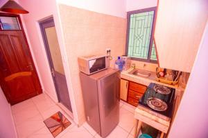 蒙巴萨Corded bamburi lakeview phase 4的小厨房配有冰箱上方的微波炉