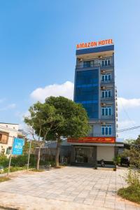 un hôtel avec un arbre devant un bâtiment dans l'établissement Amazon Hotel, à Vinh
