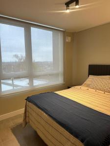 Un dormitorio con una cama y una ventana grande. en Estilo mariposa Central en distrito Icono, en Los Ángeles