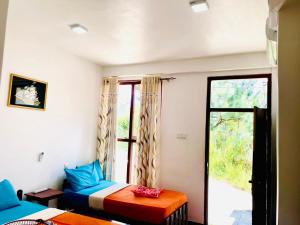 a bedroom with a bed and a window at The Ceylan Crest ELLA in Ella