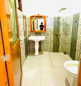 a bathroom with a sink and a mirror and a toilet at The Ceylan Crest ELLA in Ella