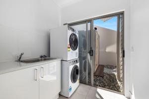 ウールグールガにあるZiggy's Beach House - Ocean views, Jacuzzi, Sauna!のキッチン(洗濯機、乾燥機、シンク付)