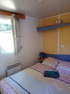 een slaapkamer met een bed en een raam bij Mobil Home in Thiviers