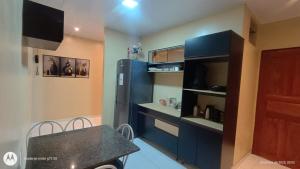 a kitchen with blue cabinets and a black refrigerator at Casa SUPER COP in Ananindeua