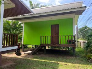 a green house with a bench in front of it at Sukanya 