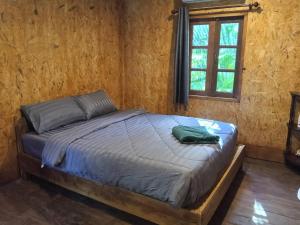 a bed in a wooden room with a window at Sukanya 