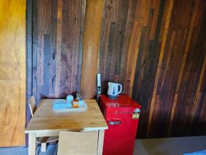 a small table and a red refrigerator in a room at Kin Kin Retreat in Quinninup +4 photos