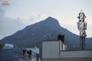 Blick auf einen Berg mit einem Sendeturm in der Unterkunft Cozy Homes, Tiruvannamalai in Tiruvannāmalai