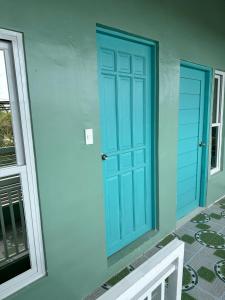 een blauwe deur aan de zijkant van een huis bij SJ Vistacation in Tanza
