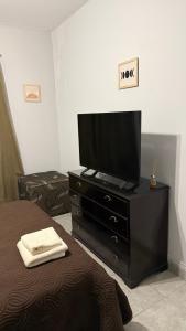 1 dormitorio con TV de pantalla plana en una cómoda en Departamento Norte 1, en San Salvador de Jujuy