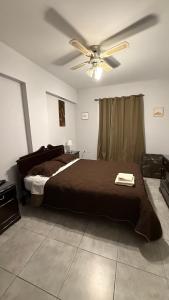 Un dormitorio con una cama y un ventilador de techo. en Departamento Norte 1, en San Salvador de Jujuy
