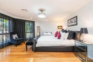 une chambre avec un grand lit et une chaise dans l'établissement Spacious Coastal Oasis - Ideal for Groups & Families, 