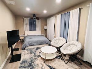 a bedroom with a bed and two chairs and a tv at Cozy Room with Private bathroom & Entrance in Carson