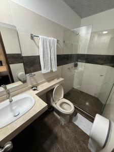 a bathroom with a toilet and a sink and a shower at Fratello Hotel in Buga +24 photos