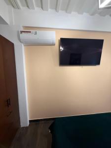 Zimmer mit einem Flachbild-TV an der Wand in der Unterkunft Fratello Hotel in Buga