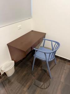 einem blauen Stuhl neben einem hölzernen Schreibtisch in der Unterkunft Fratello Hotel in Buga