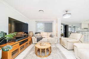 - un salon avec des canapés, une télévision et une table dans l'établissement Spacious Coastal Oasis - Ideal for Groups & Families, 