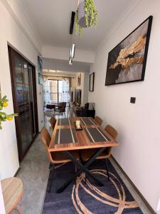 une salle à manger avec une table et des chaises en bois dans l'établissement Kipé Plaza platinium Vue Mer Appartement 2 Chambres, à Conakry