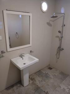 un bagno con un lavandino bianco e uno specchio di Theodore Hotel - Negombo a Negombo