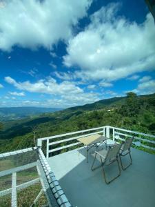 a table and chairs on a balcony with a view at Memory House ภูชี้ฟ้า เชียงราย in Ban Seng Choi