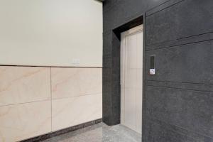 a door in a room with a wall at Super Hotel O Kachohalli Gate Formerly SRS Lodge in Tāvarikere