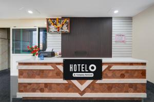 a hotel reception desk with a sign on it at Super Hotel O Kachohalli Gate Formerly SRS Lodge in Tāvarikere