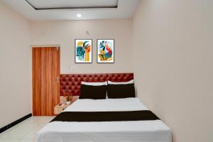 a bedroom with a large bed with a red headboard at Super Hotel O Kachohalli Gate Formerly SRS Lodge in Tāvarikere