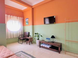 een woonkamer met een tv aan de muur bij An Homestay CN2 in Ấp Bình Hưng