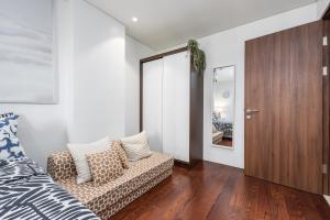 a bedroom with a bed and a couch and a mirror at Dominiks silent and quite Classic 1 Bedroom 47 sqm Tambuli Pool Balcony Beach Mactan up to 6 People in Lapu Lapu City