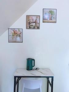 a table with four pictures on a white wall at RCM Ecolodge Inn in San Juan